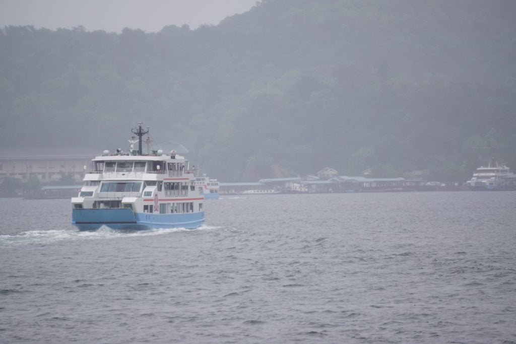 Large boat (ferry) on water traveling back from Miyajima Island in Japan