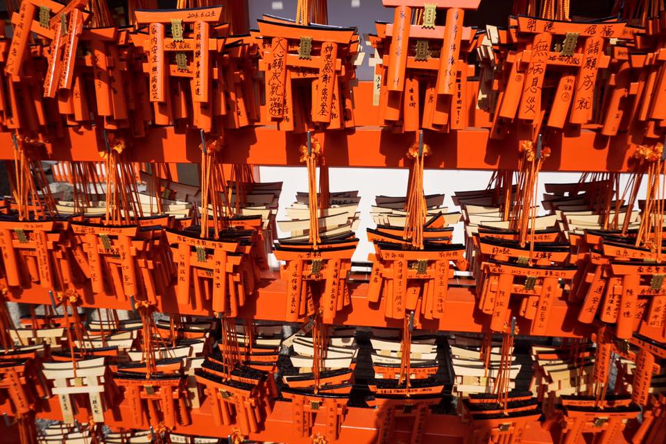 Small orange torii gates with wishes written on them at Fushimi Inari Shrine