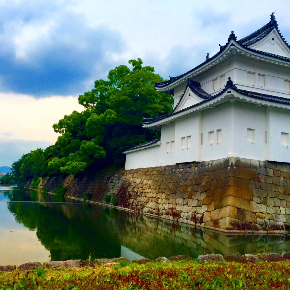 Side view of a white Japanese castle with a water moat around it. (Nijo Castle - Kyoto, Japan)