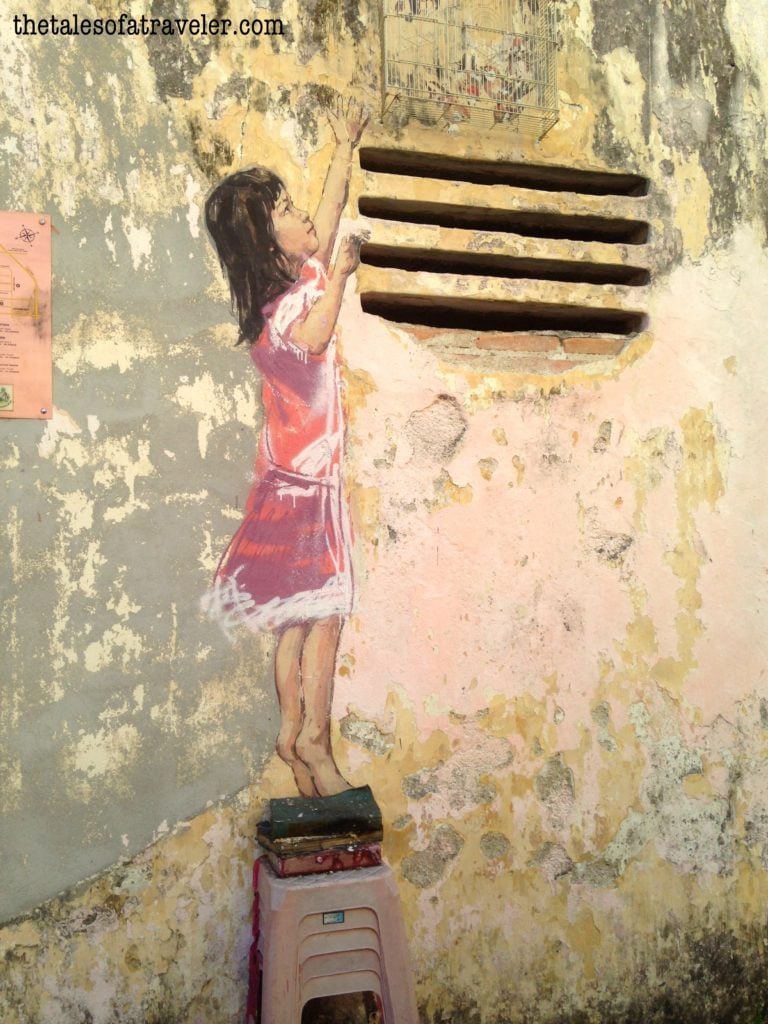 "Girl with stool and birdcage" by Ernest Zacharevic - coolest street art in Malaysia 