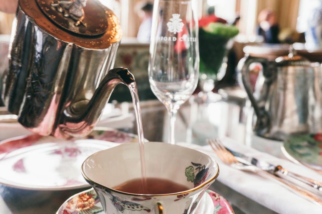 A silver tea pot pouring tea into a tea cup at Ashford Castle afternoon tea