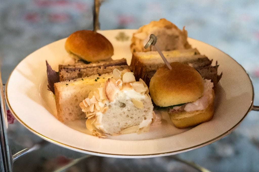 A selection of finger sandwiches on a plate.