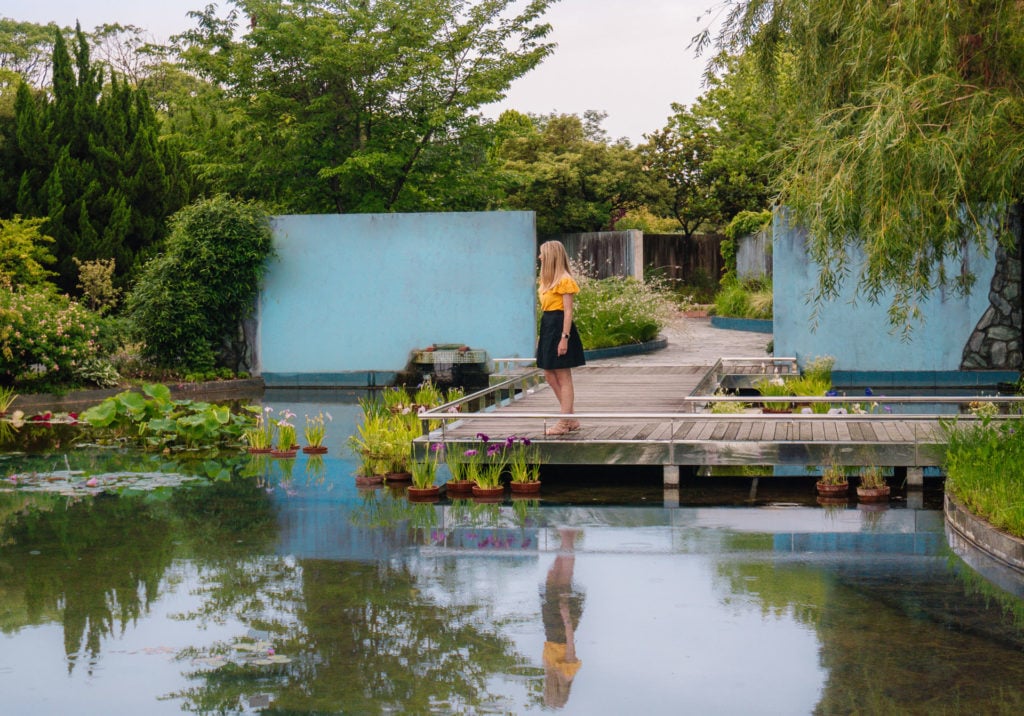 Girl standing on a dock looking out at the water of a pond at Uminonakamichi Seaside Park in Fukuoka