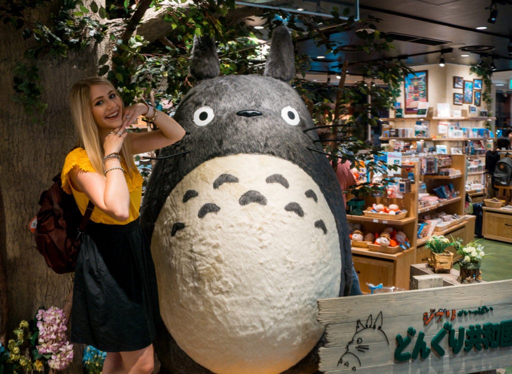 Woman posing with a statue of Totoro - Fukuoka, Japan