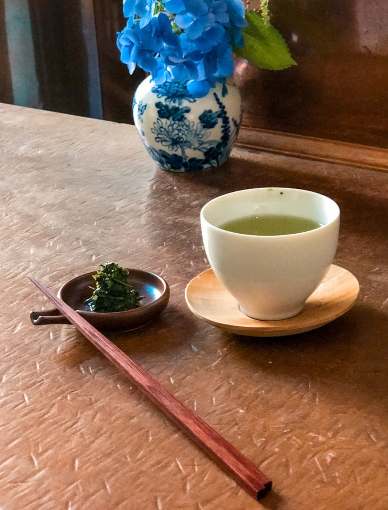 A glass of tea and a plate with tea leaves from YOROZU - Fukuoka