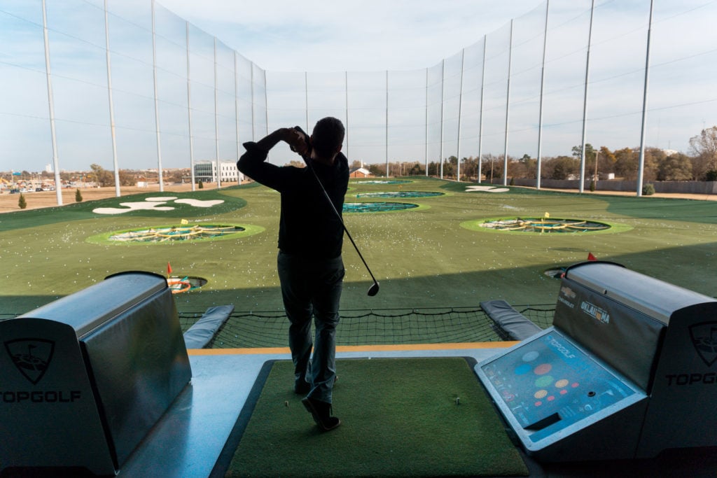 Golf swing at TopGolf Oklahoma City - couples getaway in Oklahoma