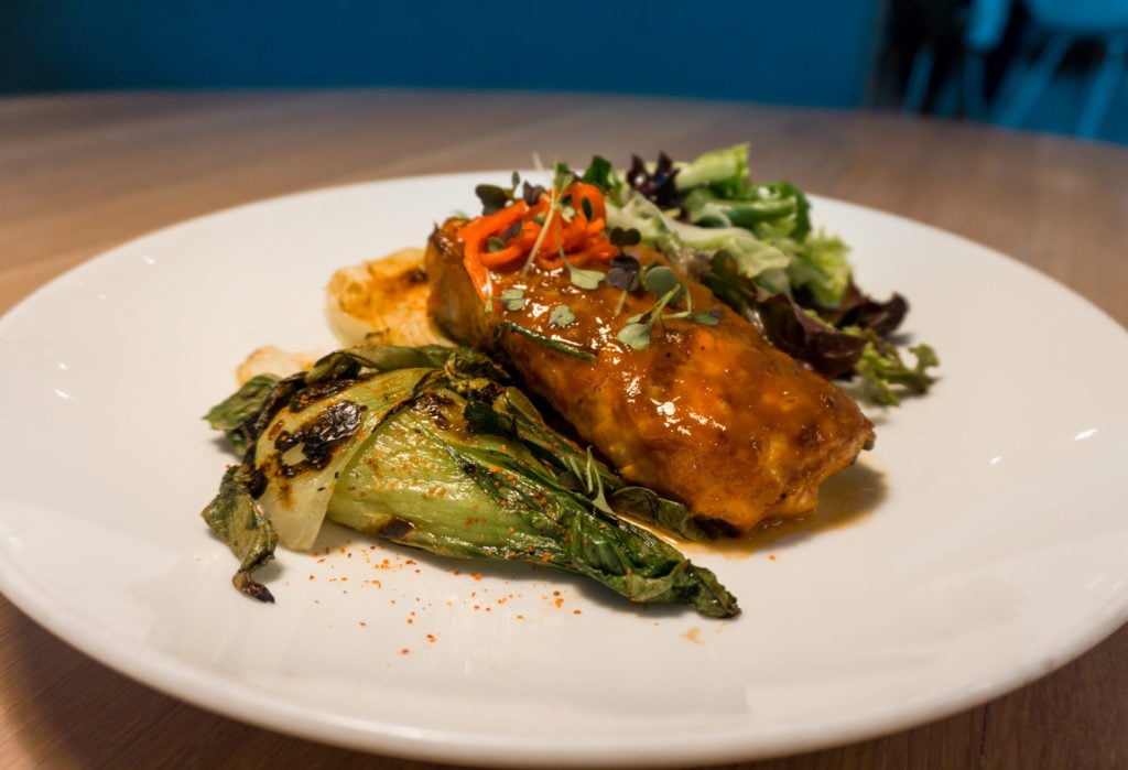 Miso glazed salmon with a side of greens from The Drake restaurant in OKC