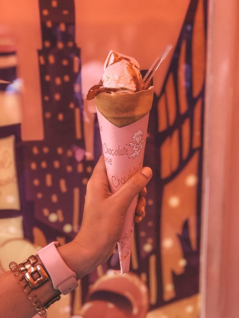 Hand holding a sweet crepe filled with ice cream and strawberries from Harajuku (Tokyo, Japan)