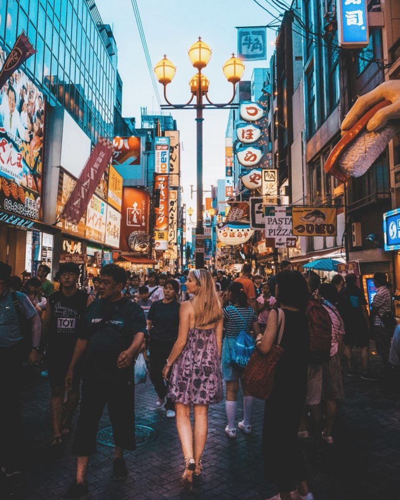 Girl walking through a crowd in the streets of Dotonbori in Osaka, Japan