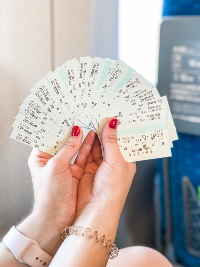 Hands holding train tickets fanned out.