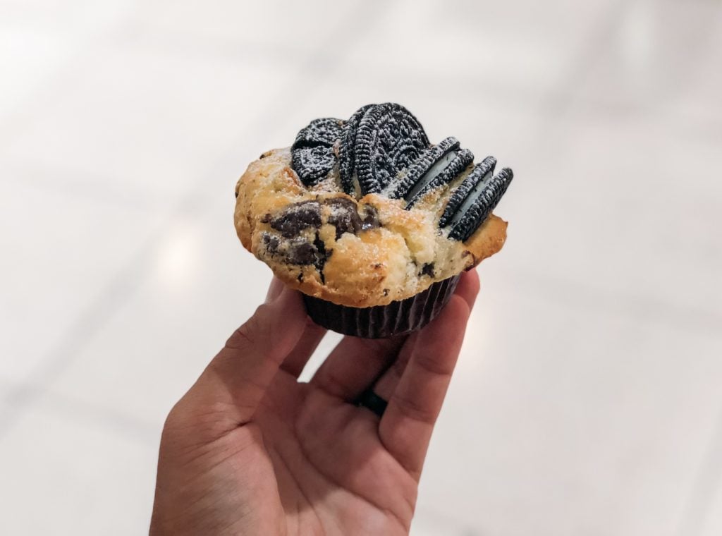 Hand holding a muffin with Oreo cookies