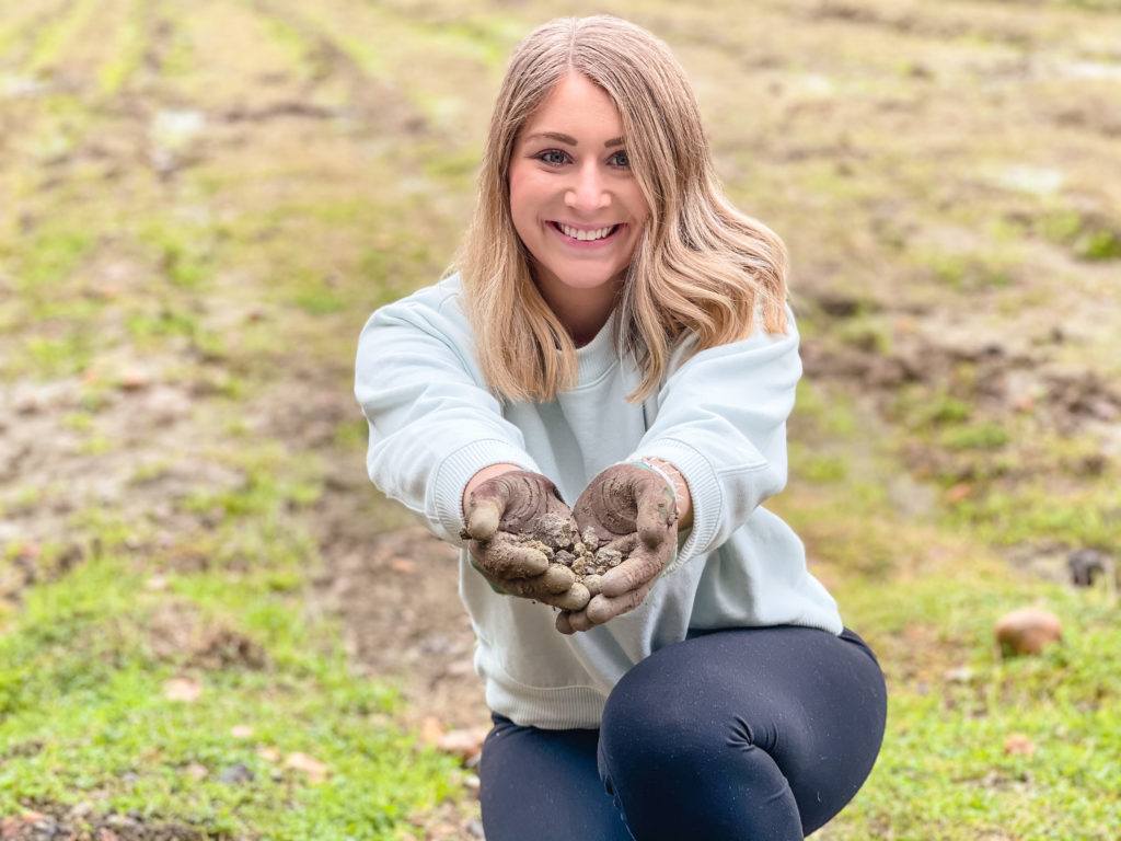 Woman with blonde hair holding different rocks and minerals at Crater of Diamonds State Park in Arkansas