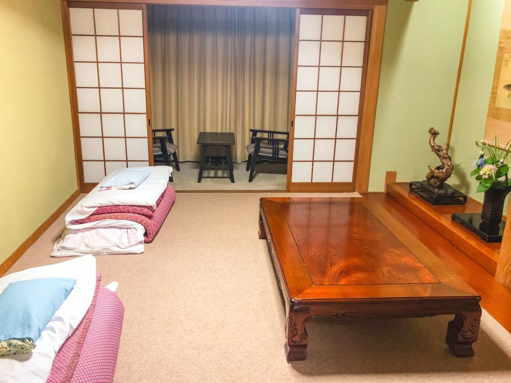 Room with two futons, a sitting area, and table at Yuhiken in Asago, Japan