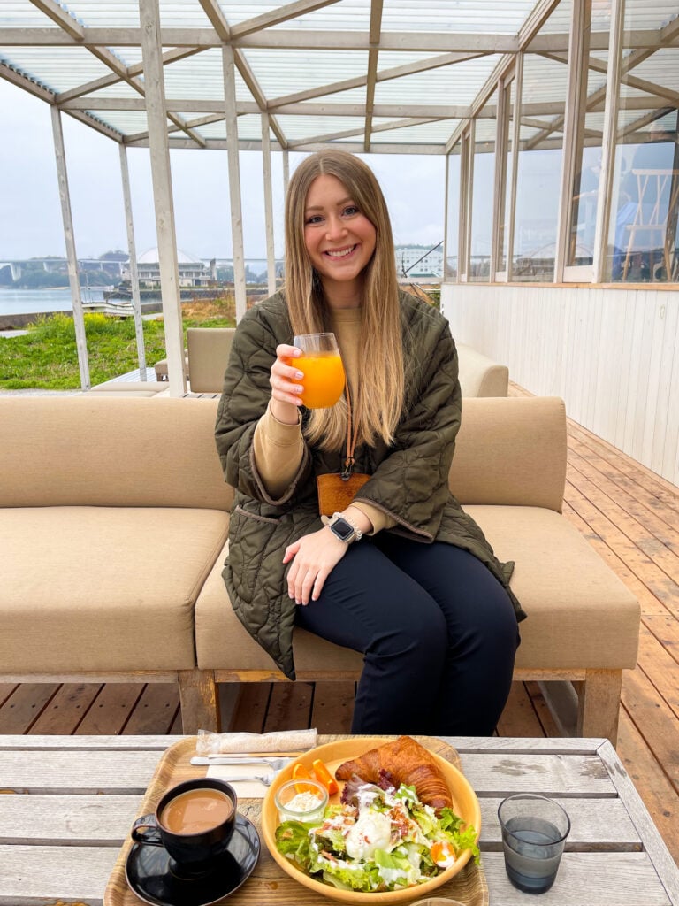 Breakfast of a salad, soft boiled egg, oranges, and croissant with coffee and juice from the cafe at WAKKA - Shimanami Kaido Hotel