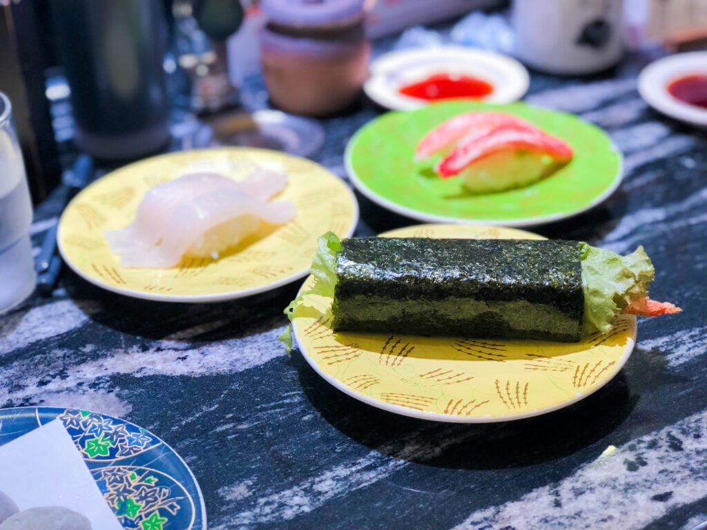 A variety of nigiri sushi and hand rolls from Nemuro Hanamaru conveyor belt sushi in Tokyo, Japan