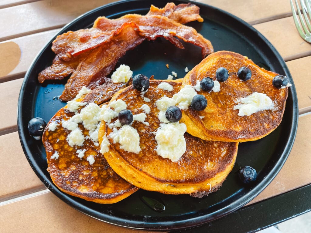 Sweet potato pancakes with goat cheese butter and blueberries and a side of bacon from State Street Eating House in Sarasota