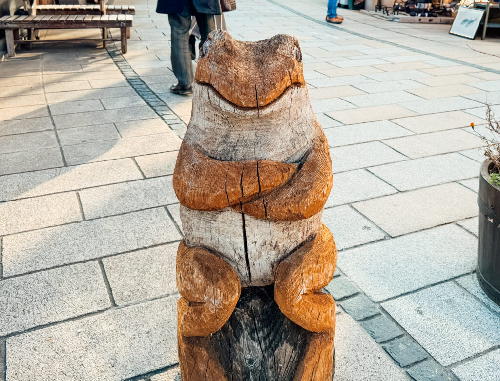 Wooden frog statue on Nawate Shopping Street in Matsumoto, Japan.