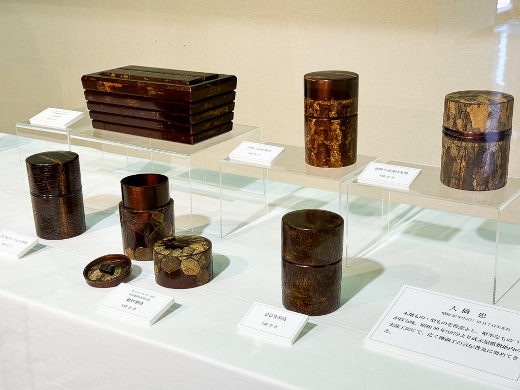 Multiple Japanese tea canisters made from cherry bark, a dark red wood with a lot of bark texture sanded smooth. These are in Kakunodate, Japan