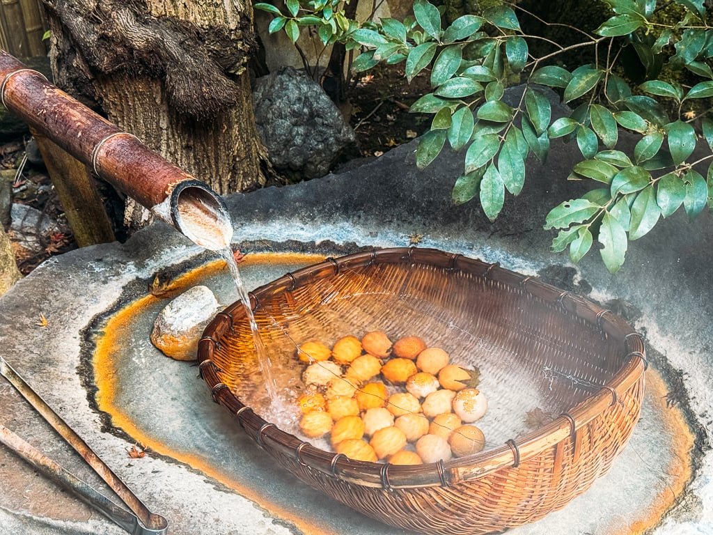 Eggs inside a woven wood basket that are being cooked in hot spring water in Kurokawa Onsen, Japan.